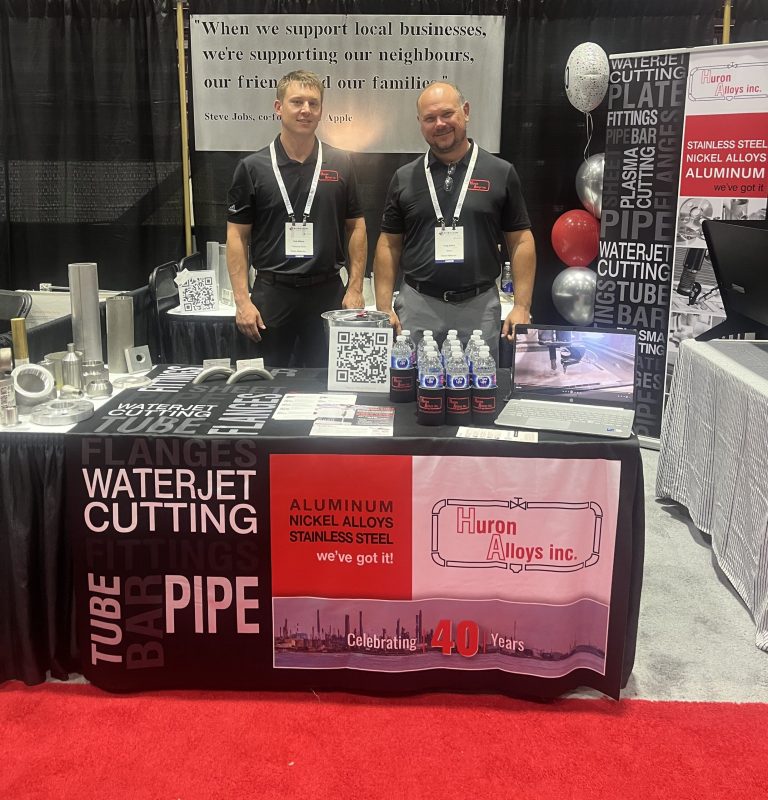 Huron Alloys trade show booth promoting pipe supply and waterjet cutting